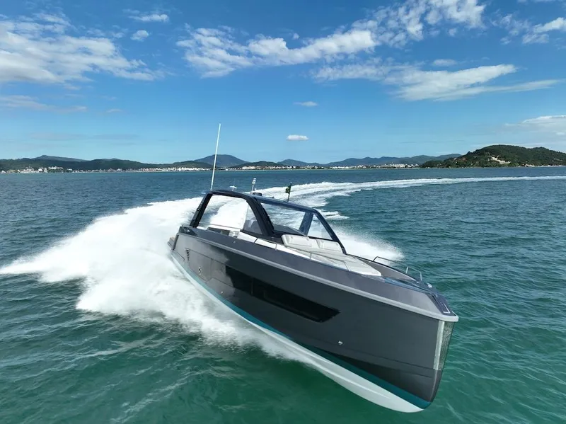 Slide: The Image of Schaefer V44 2025 luxury yacht cruising on open water with scenic coastline. - 2