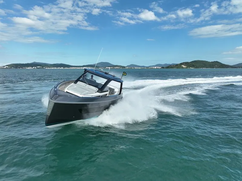 Slide: The Image of Schaefer V44 2025 luxury yacht cruising on open water with scenic mountain backdrop. - 4