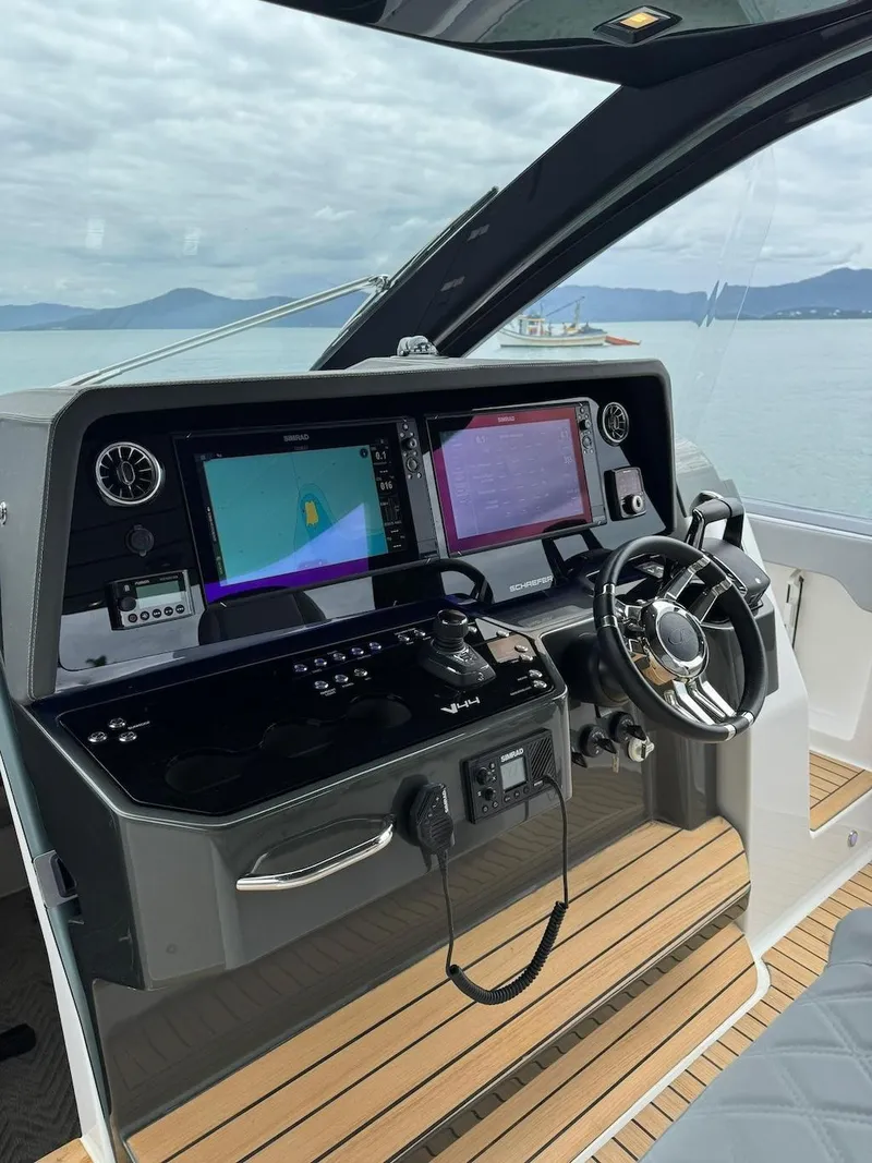 Slide: The Image of Schaefer V44 2025 yacht cockpit with advanced navigation system and steering wheel. - 12