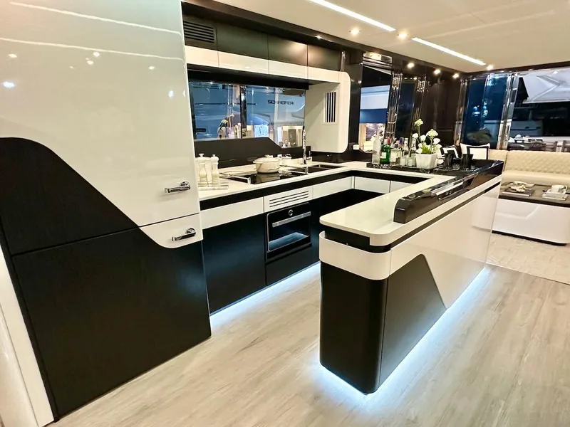 Slide: The Image of Modern kitchen interior of Schaefer 770 yacht, 2025 model, featuring sleek black and white design. - 22