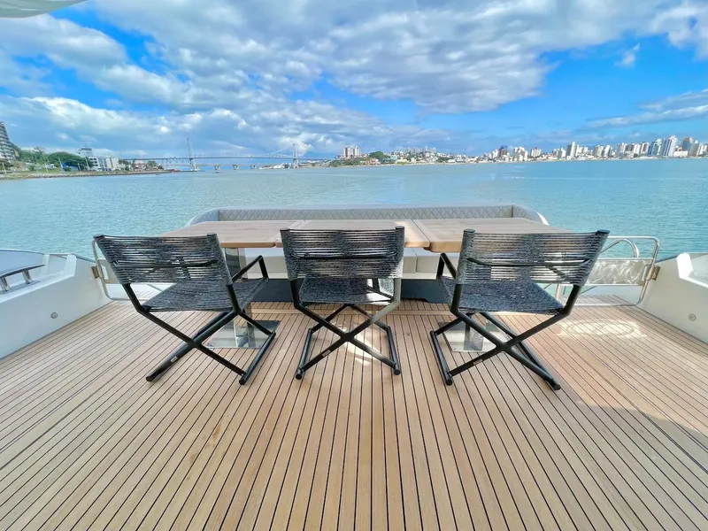 Slide: The Image of Luxury deck view on Schaefer 770 yacht, 2025 model, overlooking serene waters and cityscape. - 6