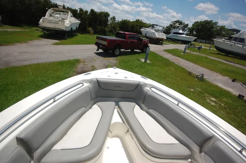 Slide: The Image of 2021 NauticStar 2102 Legacy boat interior with view of marina and parked red truck. - 11