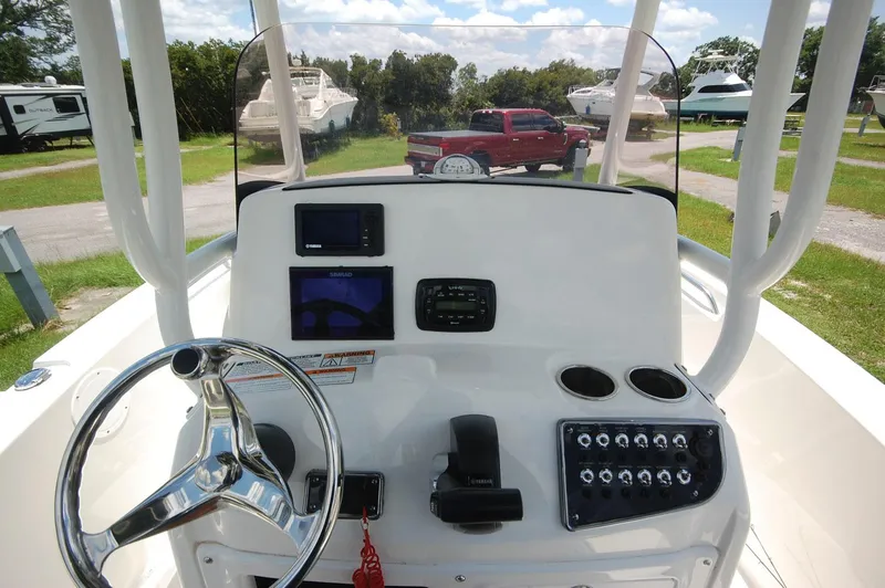 Slide: The Image of 2021 NauticStar 2102 Legacy boat console with steering wheel and navigation controls. - 16
