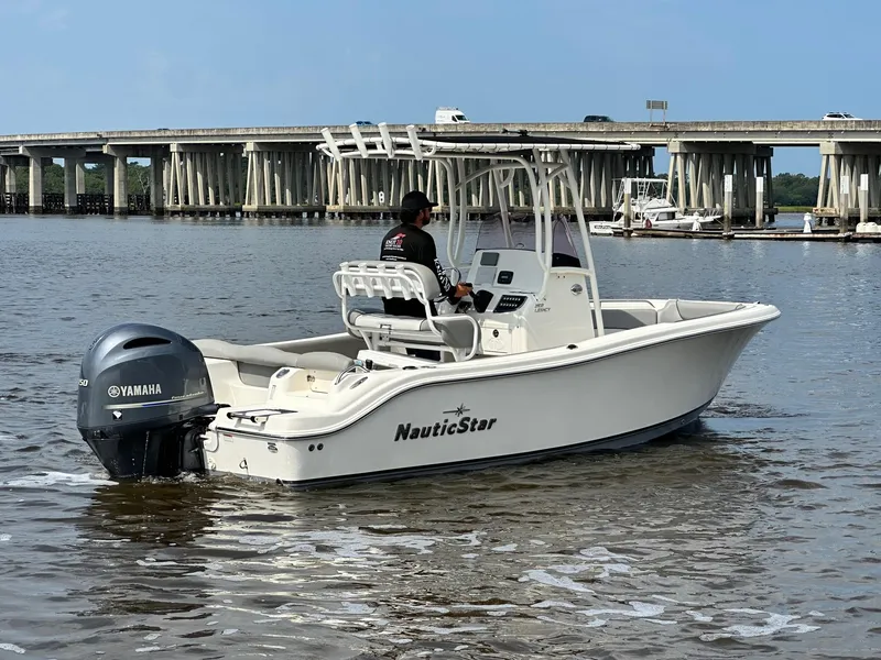 Slide: The Image of 2021 NauticStar 2102 Legacy boat on water with Yamaha outboard motor. - 2