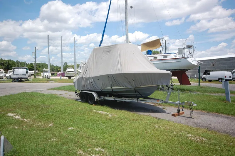 Slide: The Image of 2021 NauticStar 2102 Legacy boat covered on a trailer in a marina. - 22