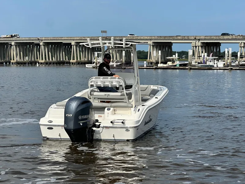 Slide: The Image of 2021 NauticStar 2102 Legacy boat on water near a bridge. - 3