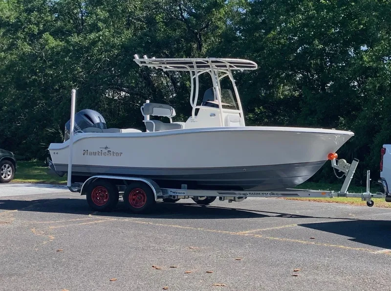 Slide: The Image of 2021 NauticStar 2102 Legacy boat on trailer, parked outdoors. - 4