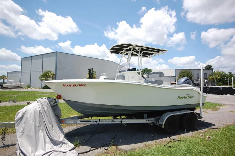 Slide: The Image of 2021 NauticStar 2102 Legacy boat on a trailer, parked outdoors. - 6