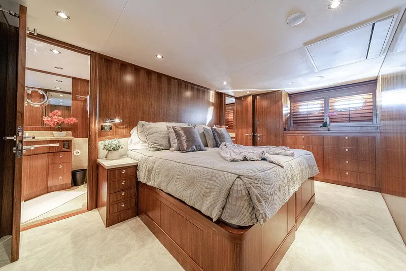 Slide: The Image of Luxurious bedroom interior on 2007 Hargrave 78 Open Bridge yacht, featuring elegant wood paneling. - 23