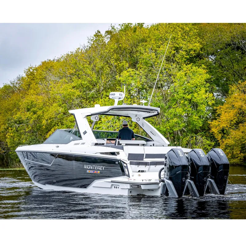Slide: The Image of 2022 Monterey 38 Super Sport boat cruising on a lake with lush green trees in the background. - 0