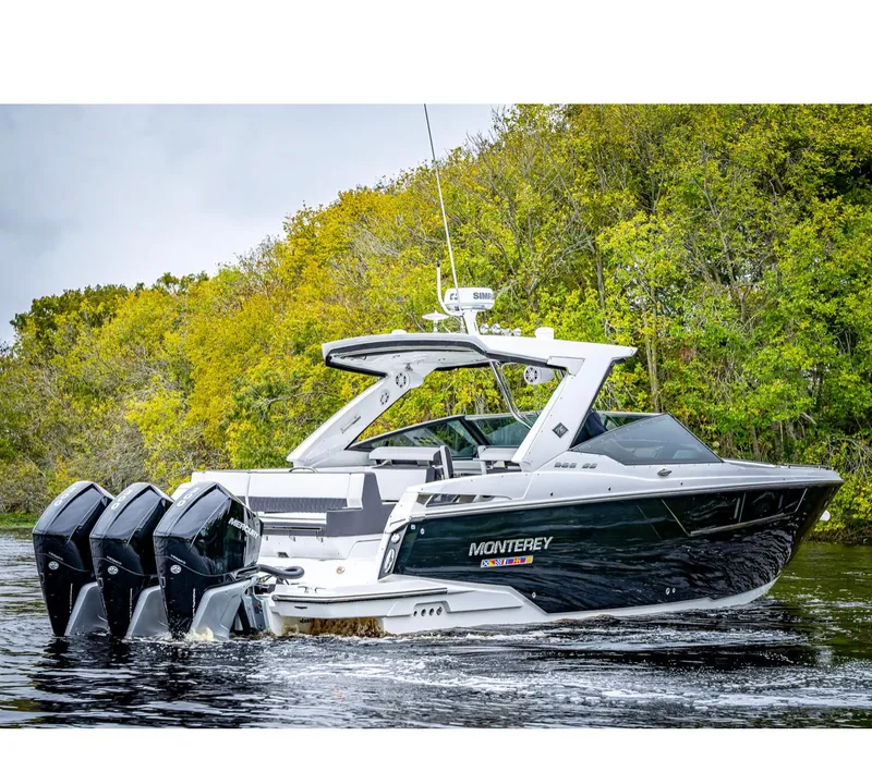 Slide: The Image of 2022 Monterey 38 Super Sport boat cruising on a lake with lush green trees in the background. - 1