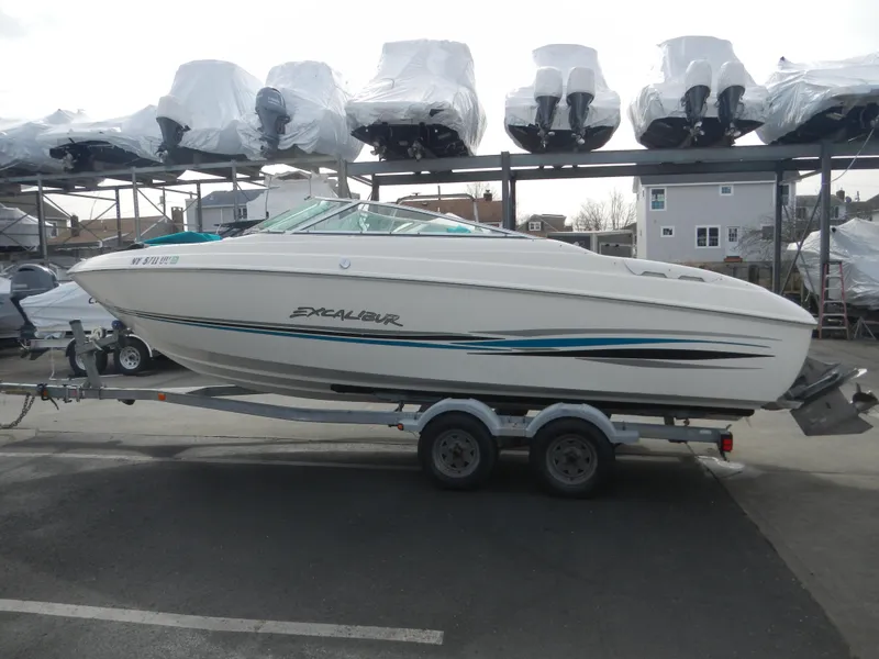 The Image of 2000 Wellcraft EXCALIBUR boat on a trailer in a marina storage area. - 0