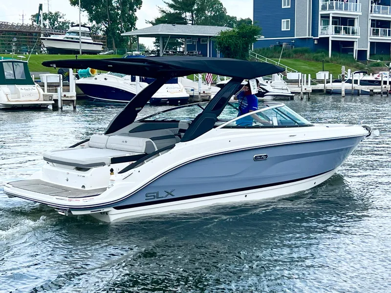 Slide: The Image of 2023 Sea Ray SLX 260 boat cruising in a marina. - 10