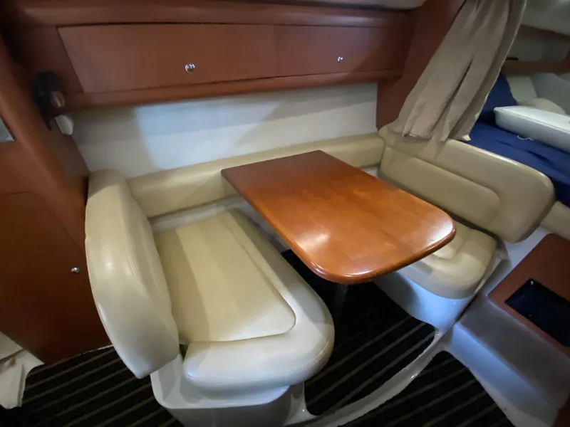 Slide: The Image of Interior of 2003 Chaparral 280 Signature boat with dining area and wooden table. - 13