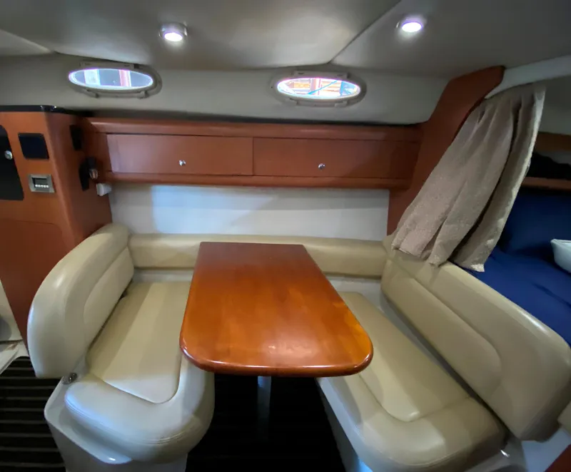 Slide: The Image of 2003 Chaparral 280 Signature cabin interior with dining area and beige seating. - 14