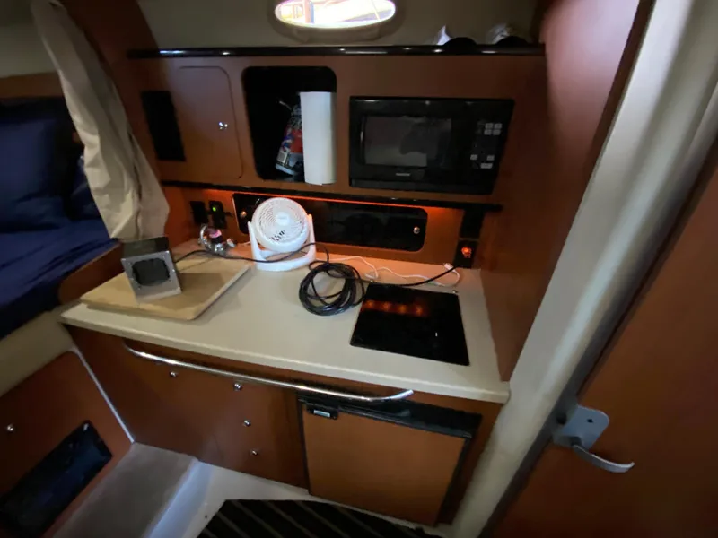 Slide: The Image of 2003 Chaparral 280 Signature boat interior with kitchenette, microwave, and fan. - 16