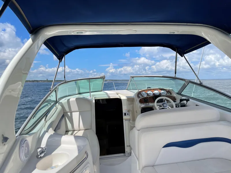 Slide: The Image of 2003 Chaparral 280 Signature boat interior with blue canopy, steering wheel, and open water view. - 4