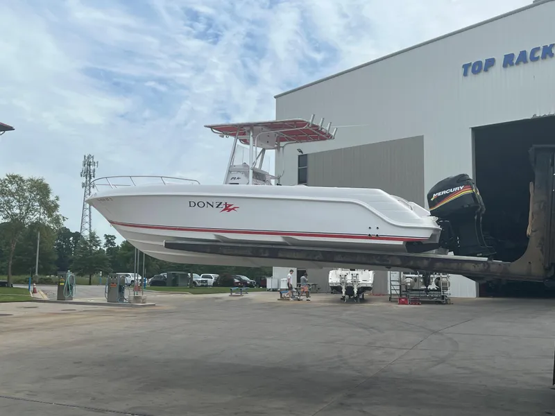 Slide: The Image of 2002 Donzi 29 ZF Cuddy boat on lift at marina. - 0