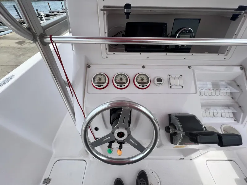 Slide: The Image of 2002 Donzi 29 ZF Cuddy boat dashboard with steering wheel and gauges. - 38