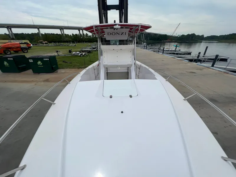 Slide: The Image of 2002 Donzi 29 ZF Cuddy boat docked by a riverside marina. - 43