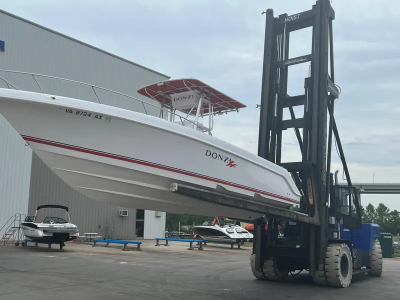 Slide: The Image of 2002 Donzi 29 ZF Cuddy boat lifted by forklift at marina. - 6