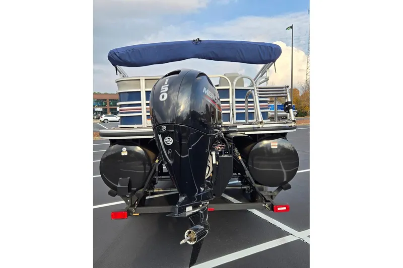 Slide: The Image of 2023 Ranger Reata 223C pontoon boat with Mercury 150 engine in parking lot. - 5