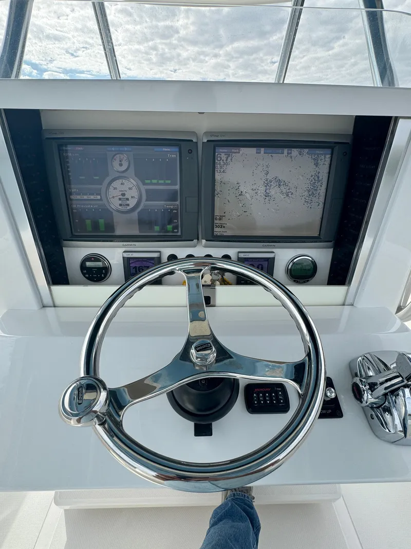 Slide: The Image of 2013 Bahama Open Fisherman helm with dual Garmin displays and stainless steel steering wheel. - 21