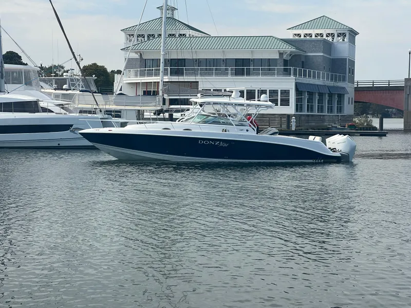 The Image of 2008 Donzi 38 ZSF boat docked in marina, with waterfront building in background. - 0