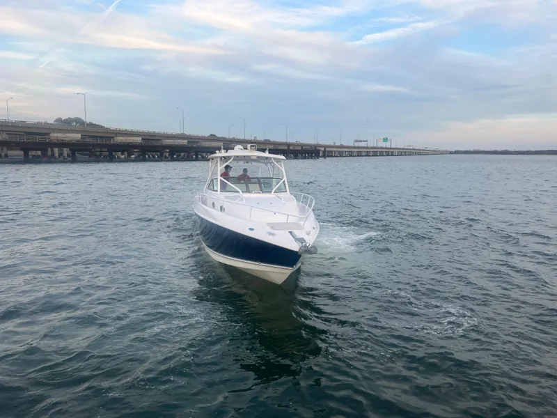 Slide: The Image of 2008 Donzi 38 ZSF boat cruising on open water near a bridge. - 12