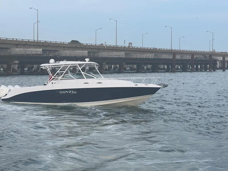 Slide: The Image of 2008 Donzi 38 ZSF boat cruising near a bridge on a calm waterway. - 14