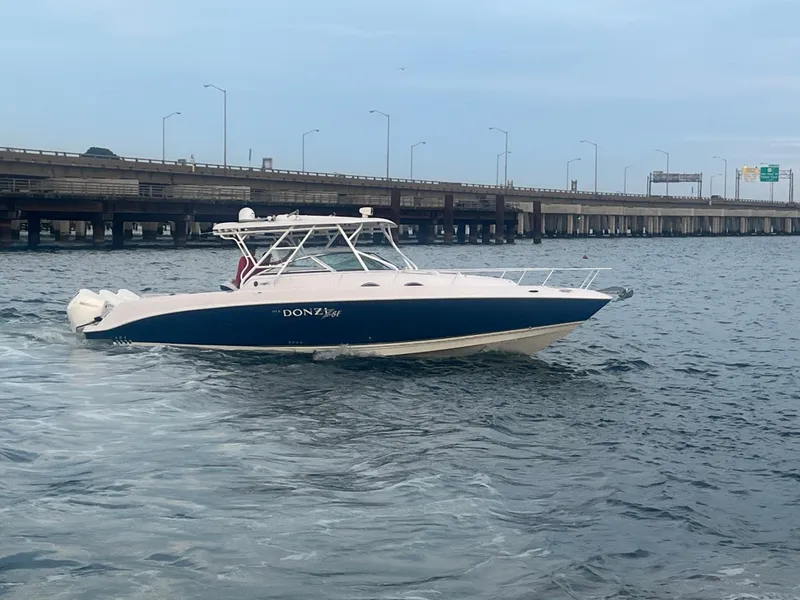 Slide: The Image of 2008 Donzi 38 ZSF boat cruising on water near a bridge. - 5