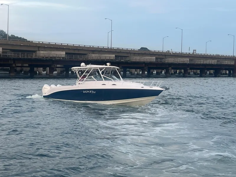 Slide: The Image of 2008 Donzi 38 ZSF boat cruising near a bridge on a calm waterway. - 13