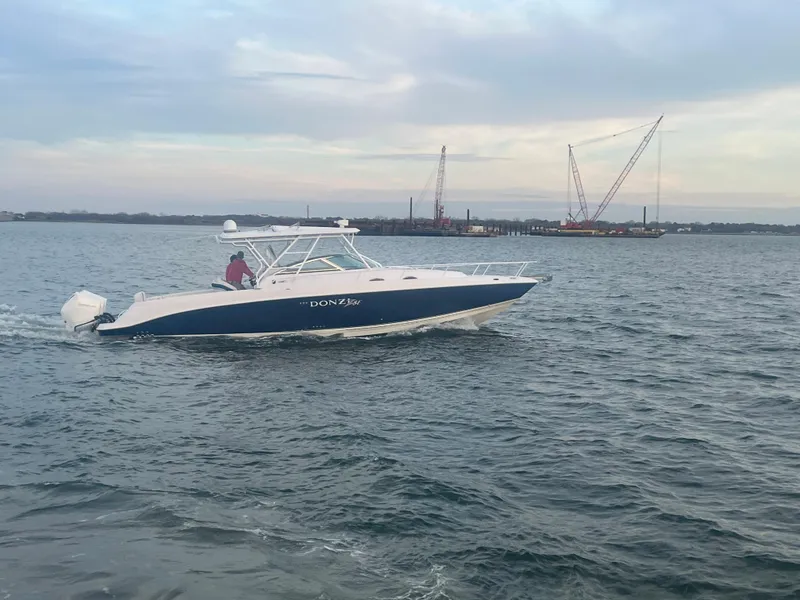 Slide: The Image of 2008 Donzi 38 ZSF boat cruising on open water with cranes in the background. - 16