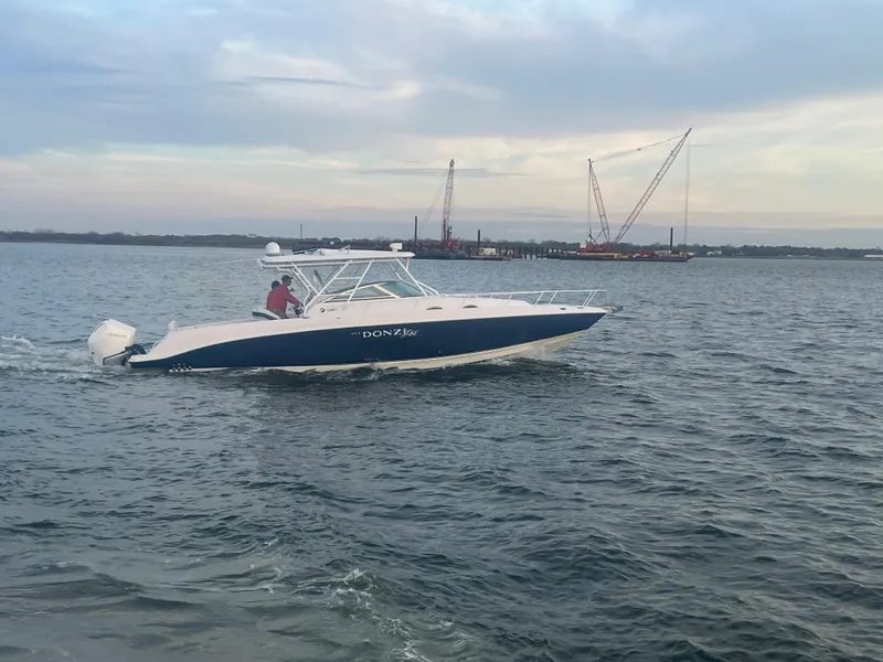 Slide: The Image of 2008 Donzi 38 ZSF boat cruising on open water with cranes in the background. - 17