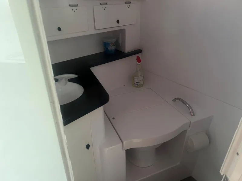 Slide: The Image of 2008 Donzi 38 ZSF boat bathroom with sink, toilet, and storage cabinets. - 25