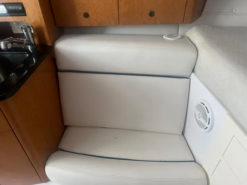 Slide: The Image of 2008 Donzi 38 ZSF cabin interior with white cushioned seating and wooden cabinetry. - 27