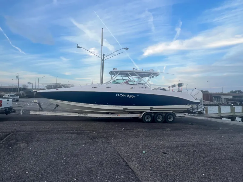 Slide: The Image of 2008 Donzi 38 ZSF boat on a trailer at a dock under a blue sky. - 7