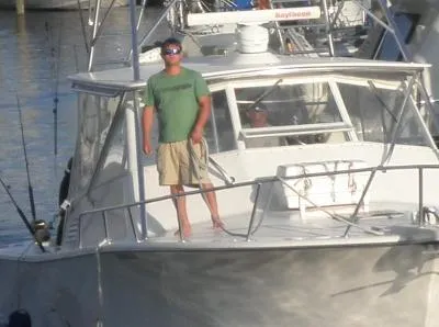 Slide: The Image of Man standing on 2002 Jersey 36 Express boat at marina. - 11