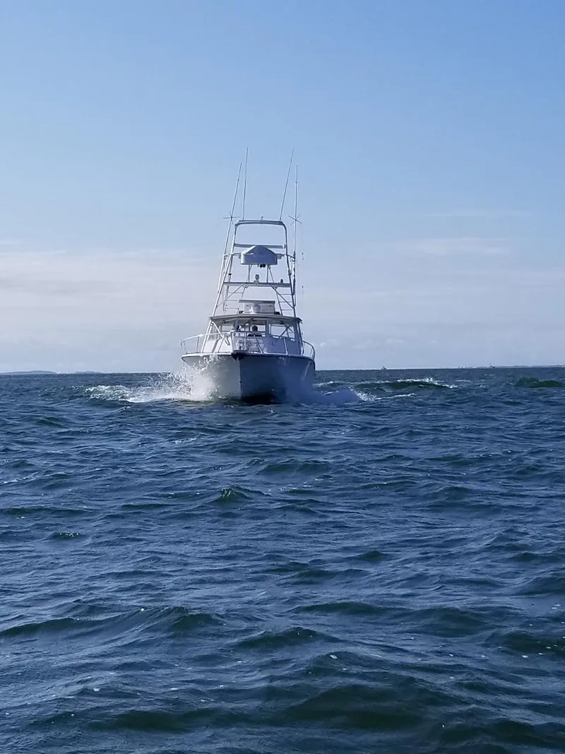 Slide: The Image of 2002 Jersey 36 Express boat cruising on open sea under clear sky. - 13