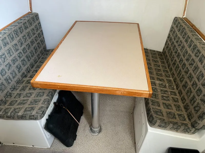 Slide: The Image of 2002 Jersey 36 Express boat interior dining area with cushioned seating and table. - 32