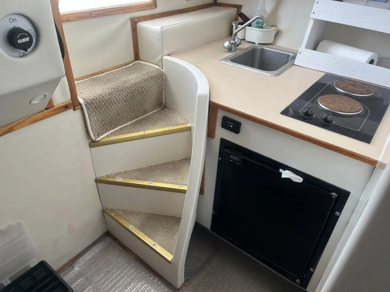 Slide: The Image of 2002 Jersey 36 Express boat interior with kitchenette, stairs, sink, and stove. - 33