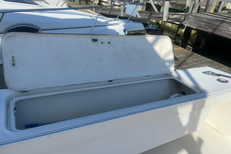 Slide: The Image of Open storage compartment on a 2002 Jersey 36 Express boat docked at a marina. - 78