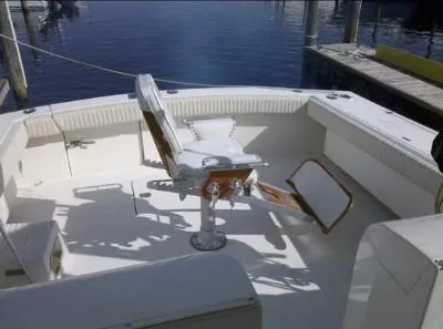 Slide: The Image of 2002 Jersey 36 Express boat deck with seating, docked by calm water. - 9