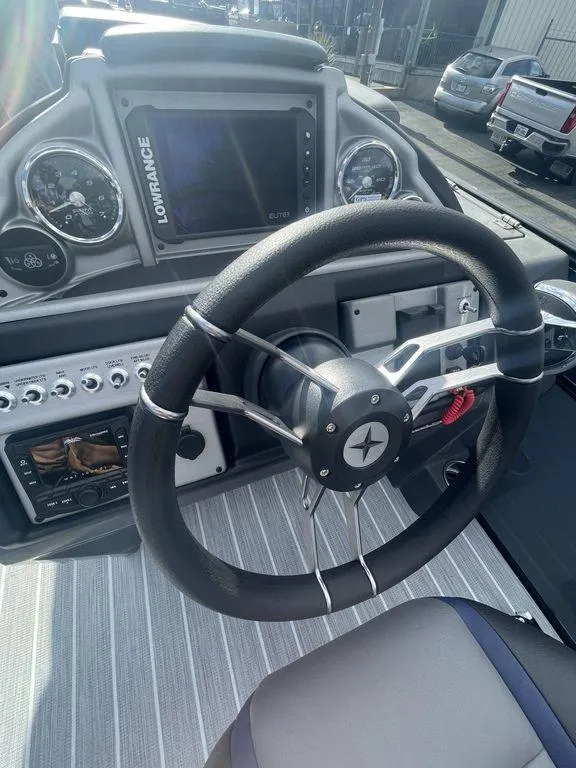 Slide: The Image of Steering wheel and dashboard of 2023 Berkshire 25UL STS 3.0 boat, featuring modern controls. - 13