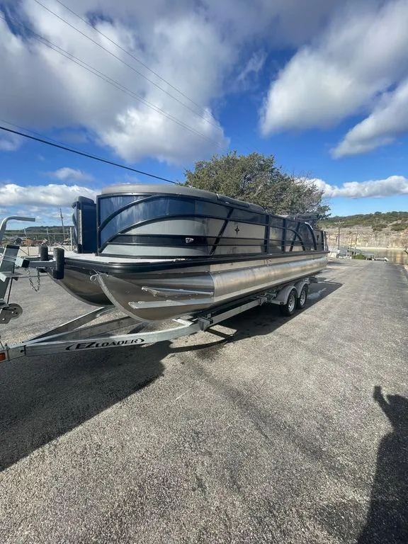 Slide: The Image of 2023 Berkshire 25UL STS 3.0 pontoon boat on trailer under a blue sky. - 6