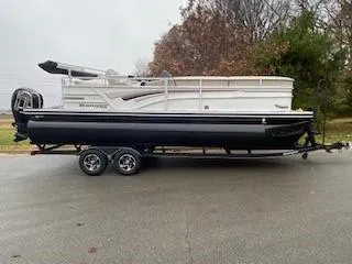 The Image of 2023 Ranger Reata 223C pontoon boat on trailer, parked on a road. - 0