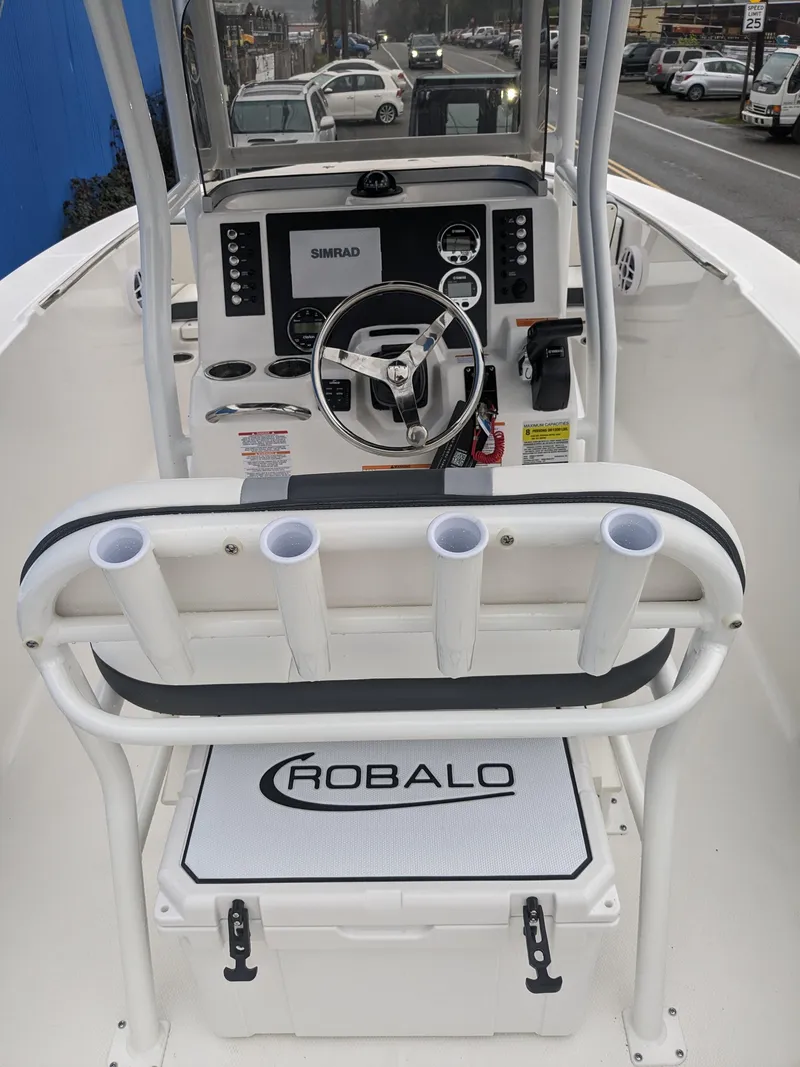 Slide: The Image of 2024 Robalo R200 Center Console boat interior with steering wheel and rod holders. - 24