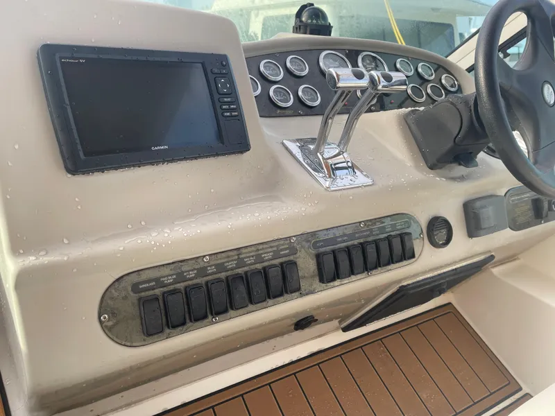 Slide: The Image of 2004 Cruisers Yachts 320 Express helm with controls, gauges, and Garmin display. - 13