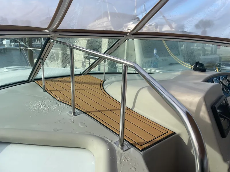 Slide: The Image of 2004 Cruisers Yachts 320 Express cockpit with teak flooring and stainless steel railings. - 15