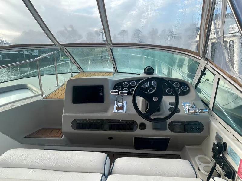 Slide: The Image of 2004 Cruisers Yachts 320 Express helm with steering wheel and navigation controls. - 17